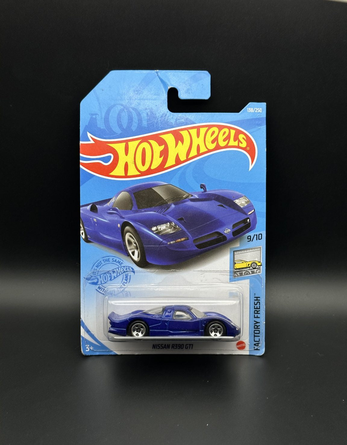 Hot Wheels toy car packaging with a blue Nissan r390 gti car on a black background