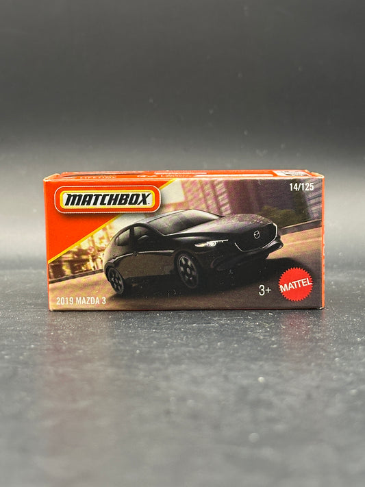 Matchbox toy car packaging on a reflective surface